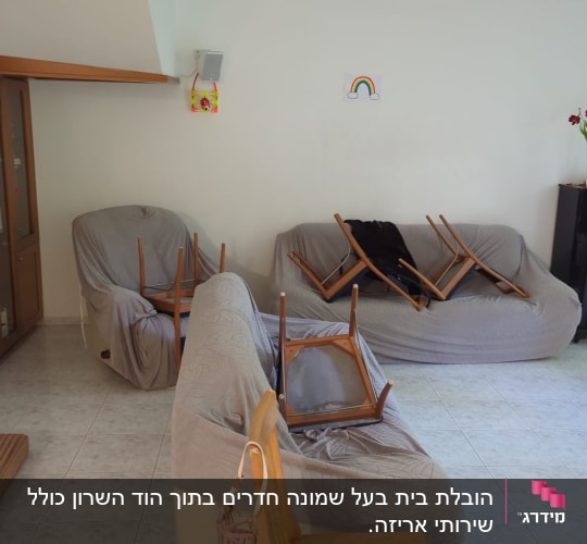 כיסאות הפוכים על ספות מכוסות בבד אפור